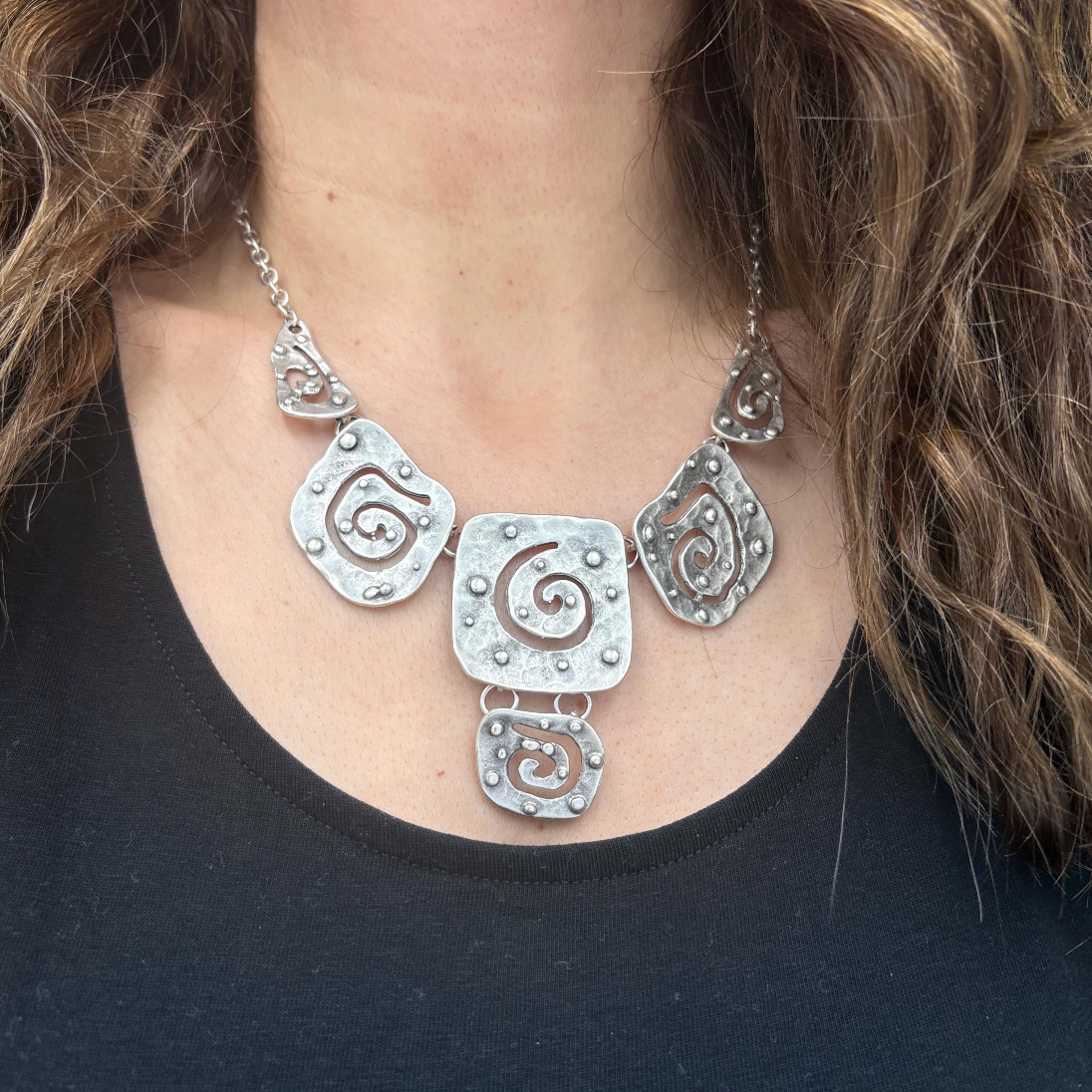 Detailed view of a vintage silver necklace with unique abstract spiral patterns.