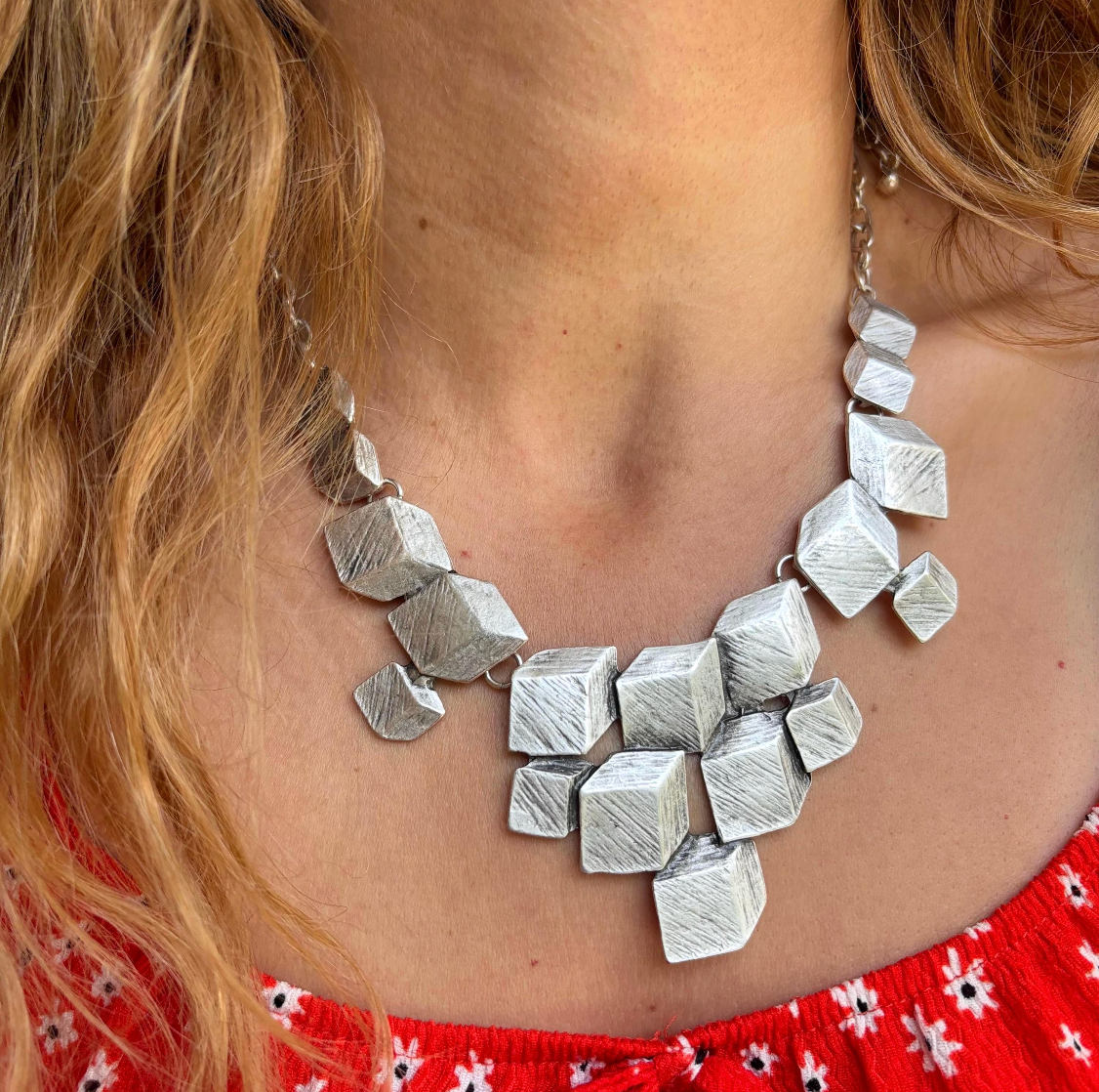 The Statement Maker: Make a bold impression with this stunning geometric cube necklace. Featuring textured silver-tone blocks in a dynamic cluster, it’s the perfect focal point for any outfit.