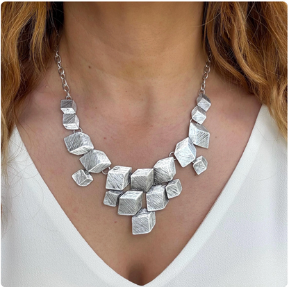 Architectural Elegance: Inspired by modern architecture, this necklace features a series of 3D cubes with a brushed matte finish. A true wearable piece of art.