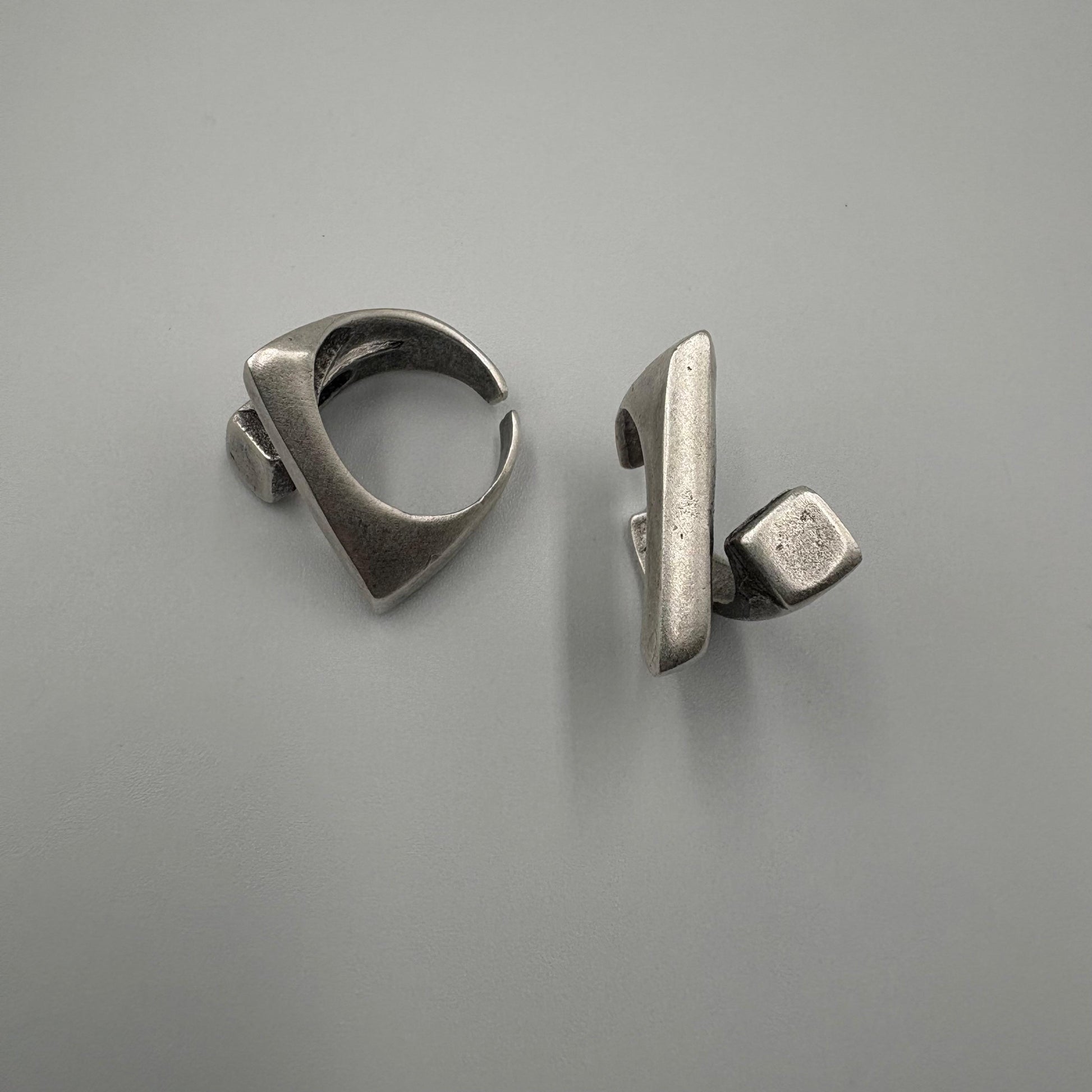 Pair of silver earrings on a gray background