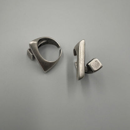 Pair of silver earrings on a gray background