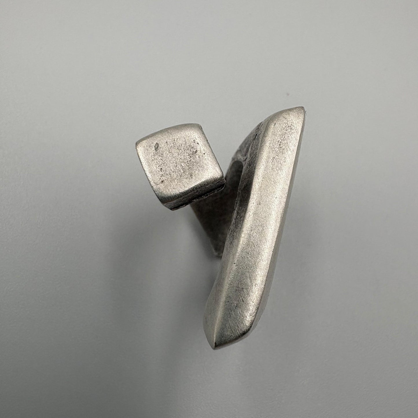 Metallic object with a geometric design on a gray background