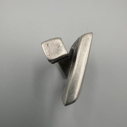 Metallic object with a geometric design on a gray background