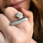 Close-up of a hand wearing two silver rings with a blurred background