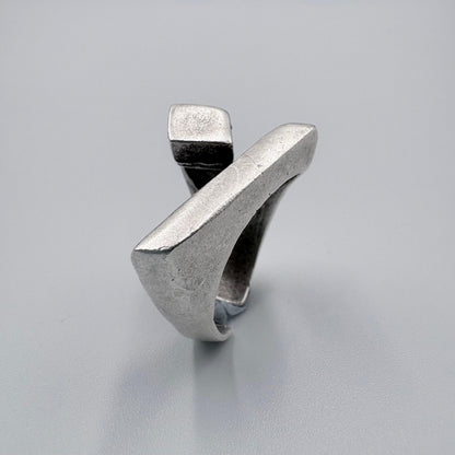 Silver ring with a modern design on a light gray background