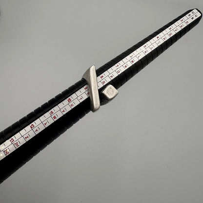Black measuring tape with white measurement markings on a gray background