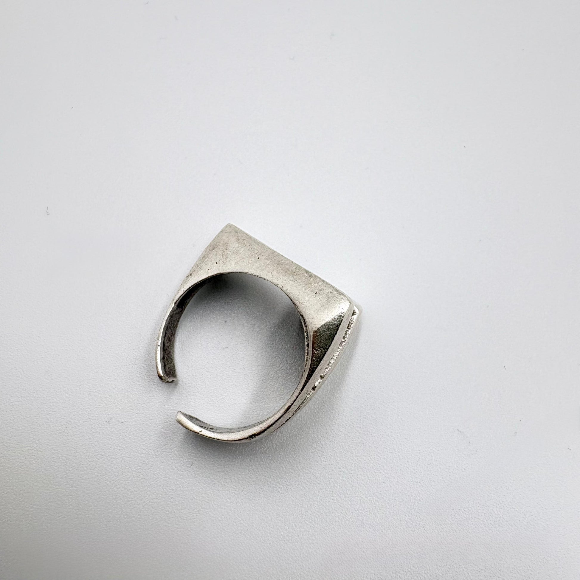 Silver ring with geometric design on a light gray background