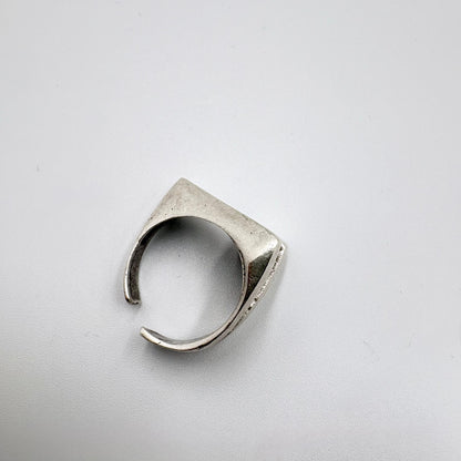 Silver ring with geometric design on a light gray background