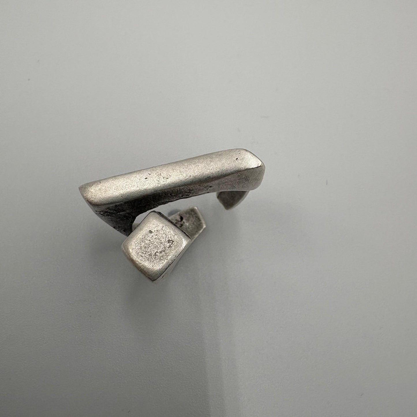 Silver ring with a unique design on a gray background