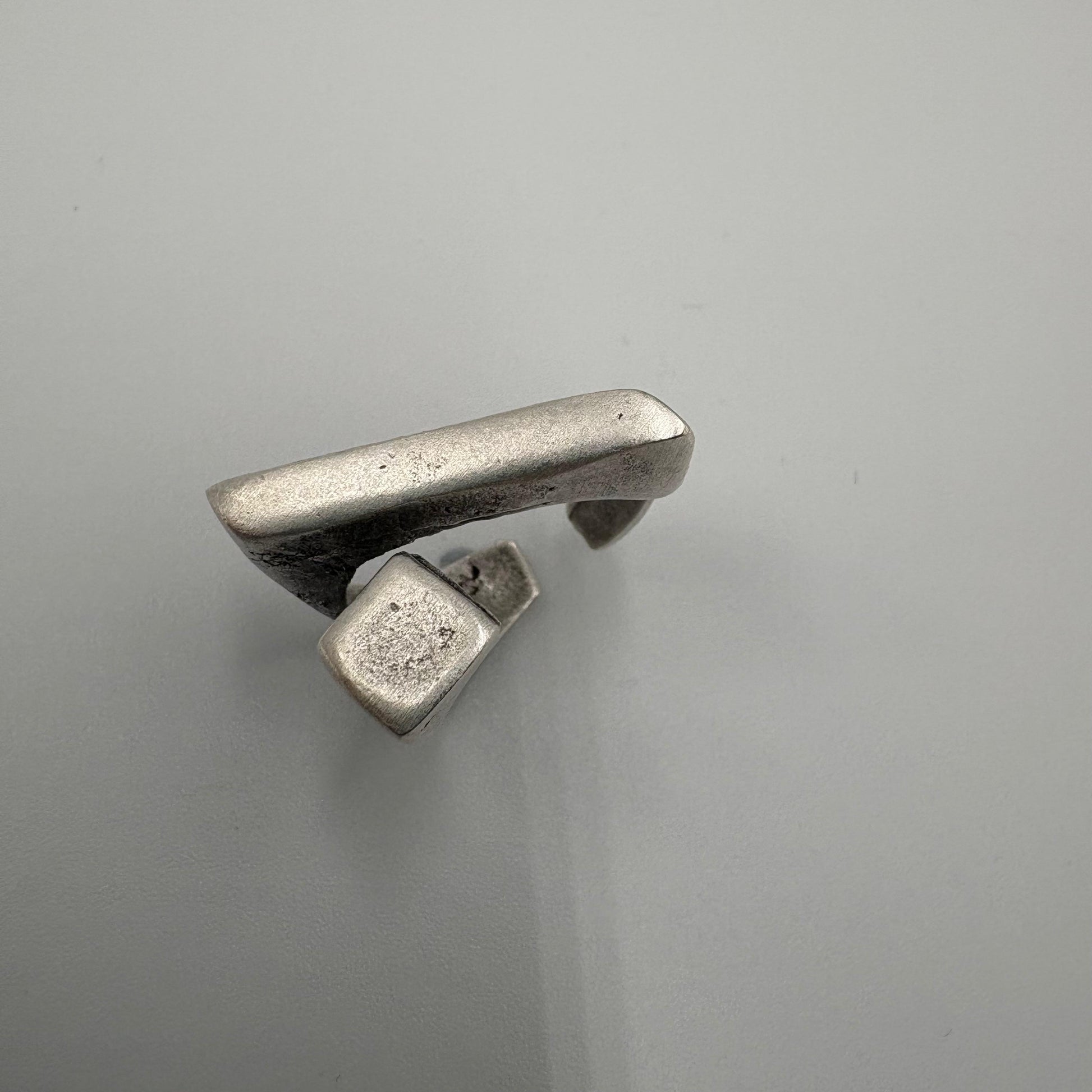 Silver ring with a unique design on a gray background