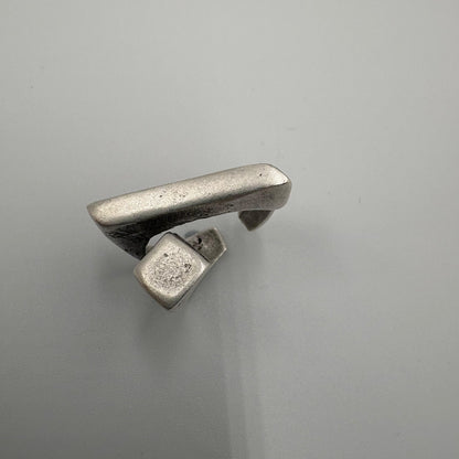 Silver ring with a unique design on a gray background