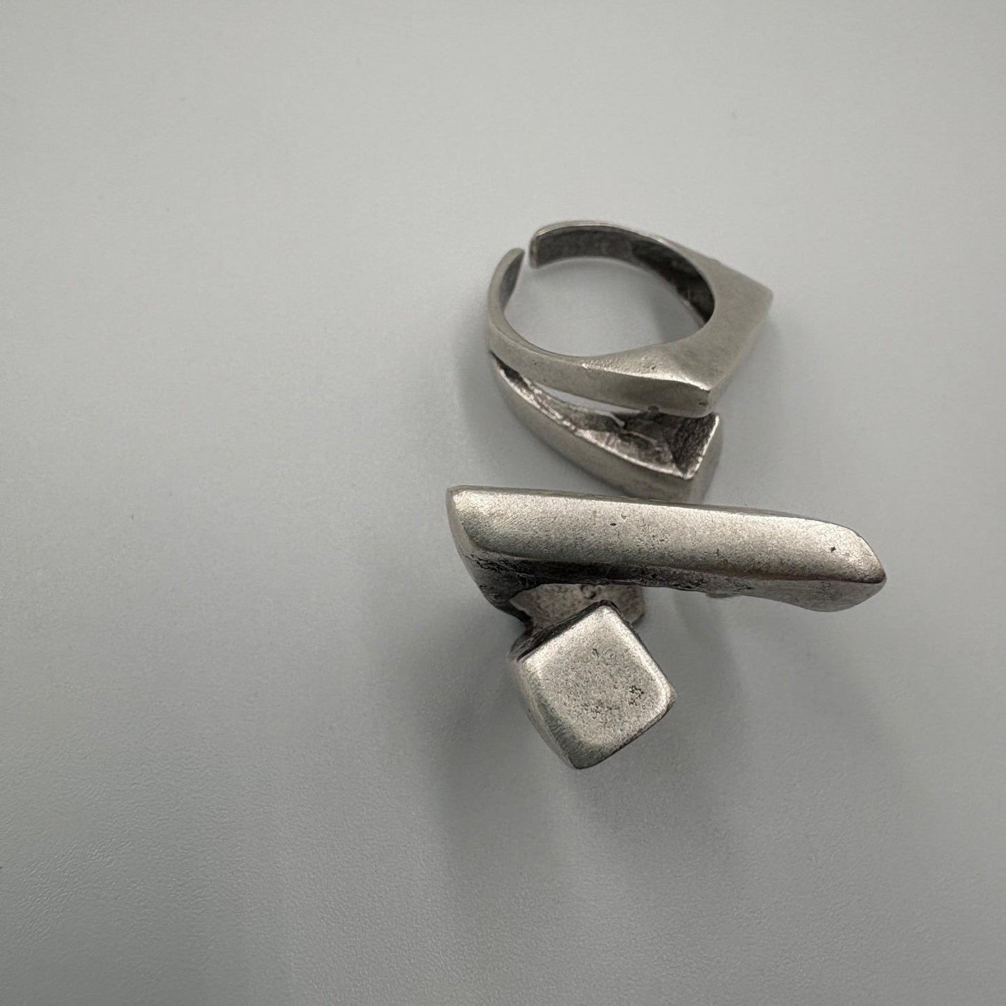 Two silver rings on a gray background