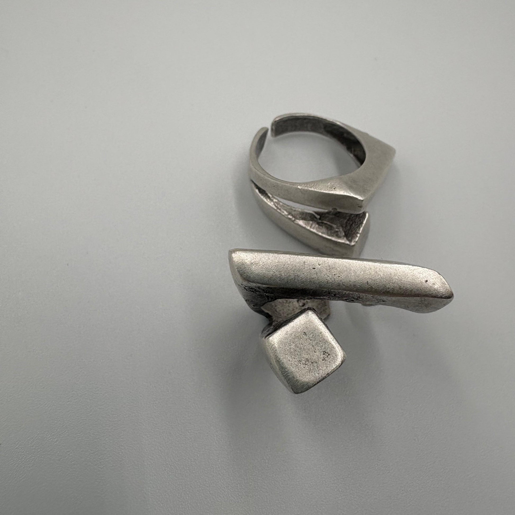 Two silver rings on a gray background