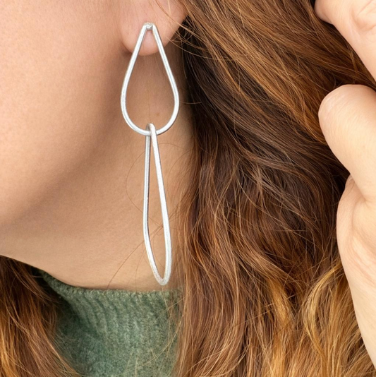 Sculptural geometric teardrop earrings in silver with a minimalist modern dangle design