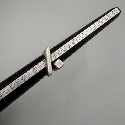 Close-up of a measuring tool with black handle and white measurement scale on a gray background