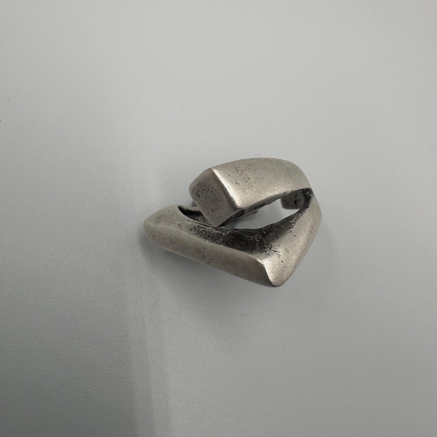 Silver ring with a geometric design on a light gray background