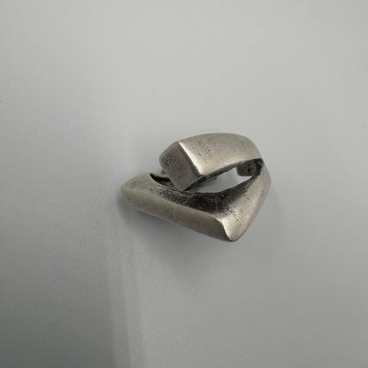 Silver ring with a geometric design on a light gray background
