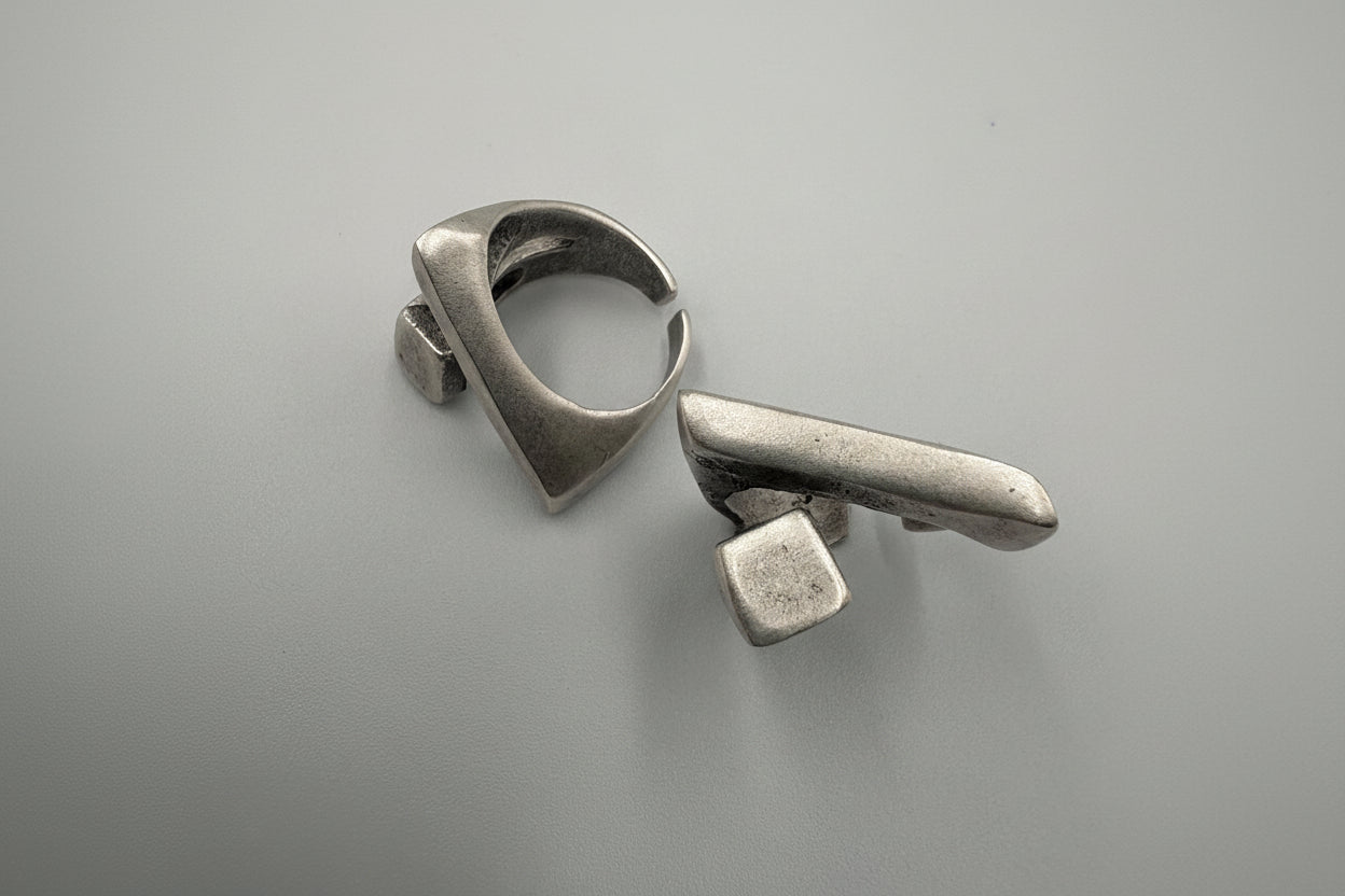 Pair of silver earrings on a gray background