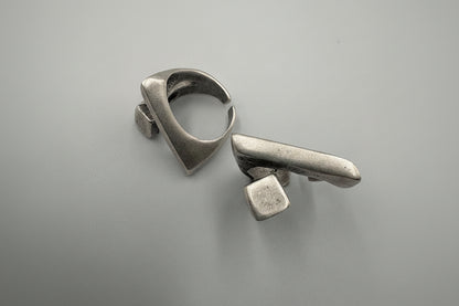 Pair of silver earrings on a gray background